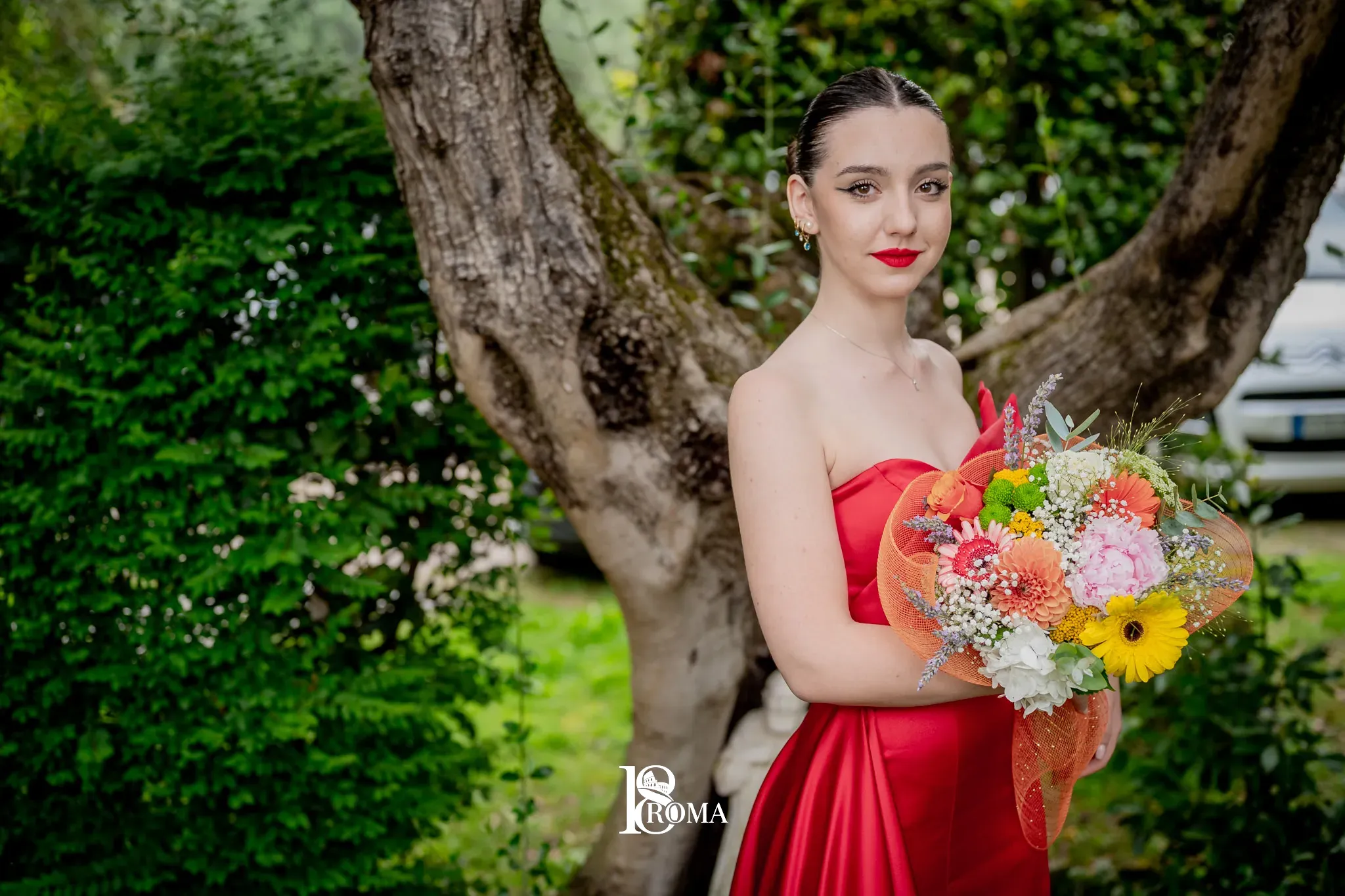 Ragazza con un mazzo di fiori sotto un albero